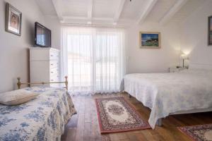 a bedroom with two beds and a window at Holiday home in Vrbnik - Insel Krk 13634 in Vrbnik +42 photos