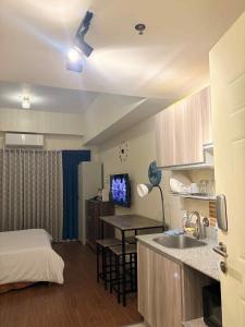 a room with a bed and a kitchen with a sink at Arlowes at 20f Grand Residences Cebu in Cebu City +11 photos