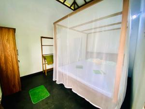 Un dormitorio con una cama cubierta con una cortina de plástico en Talalla Wonder View, en Talalla South