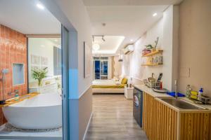 een badkamer met een bad en een wastafel en een ligbad bij Aimee House Vũ Miên in Hanoi