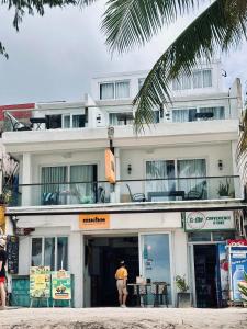 a man standing in front of a white building at Zuzuni Boutique Hotel in Boracay