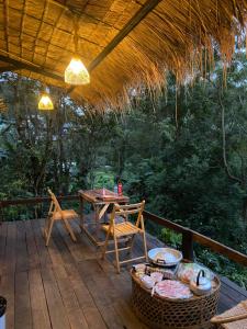 a patio with a table and chairs on a deck at อะบู้ศรีโฮมสเตย์ in Ban Huai Khai