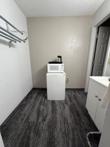 a small room with a microwave on top of a refrigerator at Regency Inn in Dodge City