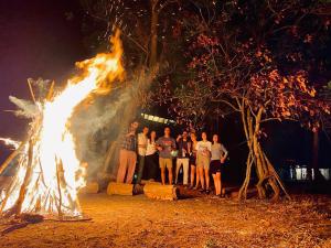 a group of people standing around a fire at Mango Tree Villa in Sigiriya