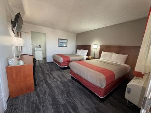 a hotel room with two beds and a television at Regency Inn in Dodge City