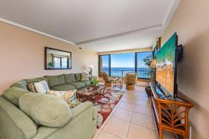 Una sala de estar con un sofá y un televisor. en Maui Kai 808 · MK 808 OceanFront 1BD Kaanapali Beach Ocean Views, en Lahaina