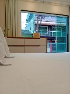 ein leeres Zimmer mit einem großen Fenster und einem Bett in der Unterkunft Apartamento entre marés-Paraty in Angra dos Reis