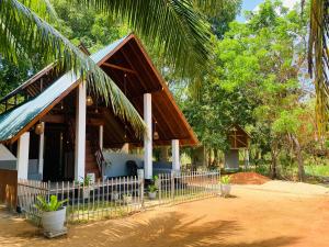 a house with a fence in front of it at Mango Tree Villa in Sigiriya +16 photos