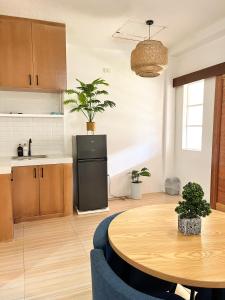 a kitchen with a table and a kitchen with a refrigerator at Zand Pointe Suites in General Luna