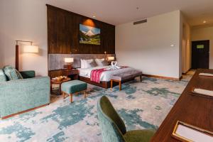 パロにあるDawa at Hilltop by Heetonのベッドとテーブルと椅子のあるホテルの部屋