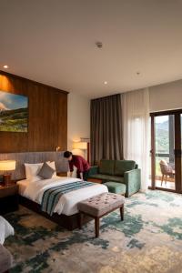 パロにあるDawa at Hilltop by Heetonのベッドと人が部屋にいるホテルの部屋