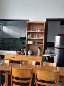 a kitchen with a table and chairs and a refrigerator at EasyLife Villa Hội An in Tân Thành (1)