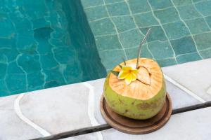a coconut with a flower on it sitting next to a pool at Tiga Villas in Kuta Lombok