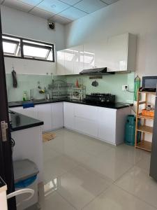 a large kitchen with white cabinets at EasyLife Villa Hội An in Tân Thành (1)