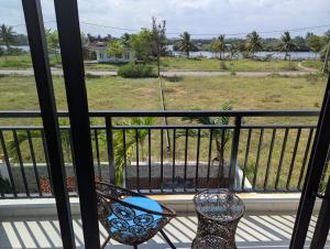 a balcony with two chairs and a view of the ocean at EasyLife Villa Hội An in Tân Thành (1)