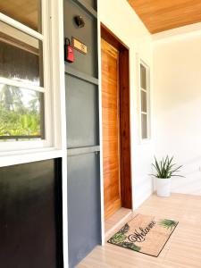 une porte d'une maison avec une fenêtre et un paillasson dans l'établissement Zand Pointe Suites, à General Luna