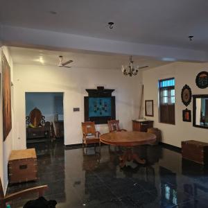a living room with a wooden table and chairs at Yali Homestay in Kuilapayam