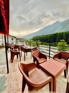 Un grupo de mesas y sillas en un balcón. en Royal Link Way near by Pizza Hut Maal Road 1km, en Manali