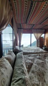un grand lit dans une chambre avec une grande fenêtre dans l'établissement Chà Homestay, à Bắc Yên
