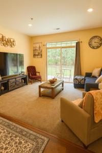 a living room with a couch and a tv at Game Day Getaway 5 Min from Notre Dame in Mishawaka