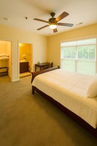 a bedroom with a large bed and a ceiling fan at Game Day Getaway 5 Min from Notre Dame in Mishawaka