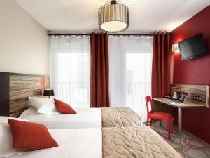 a hotel room with two beds and a desk at Aparthotel Adagio Lyon Patio Confluence in Lyon