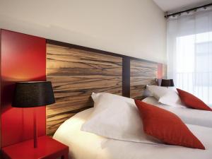 a bedroom with two beds and a wooden wall at Aparthotel Adagio Lyon Patio Confluence in Lyon +52 photos
