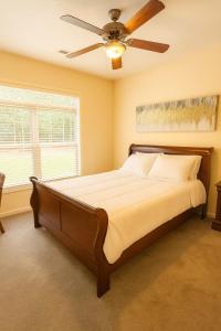 a bedroom with a large bed with a ceiling fan at Game Day Getaway 5 Min from Notre Dame in Mishawaka +30 photos
