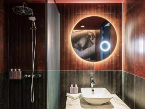 a bathroom with a sink and a shower with a mirror at Tribe Amsterdam City in Amsterdam