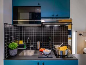 uma cozinha com pia e bancada em Aparthotel Adagio Access Kiel City em Kiel