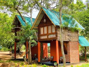 a cabin in the woods with a blue roof at Mango Tree Villa in Sigiriya