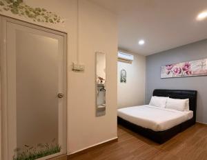 a bedroom with a bed and a door to a room at Jade Guesthouse Jonker Street Melaka in Malacca