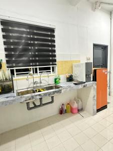 a kitchen with a sink and a counter top at Homestay Bandar Sejahtera in Pokok Sena