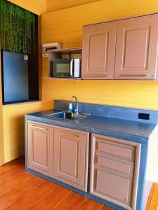a kitchen with a sink and a microwave at ห่มฟ้าโพธิ์แค้มป์ปิ้ง 