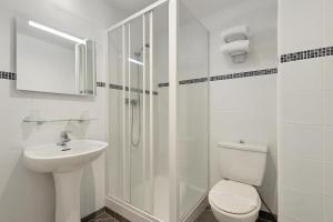 ein weißes Badezimmer mit Toilette und Waschbecken in der Unterkunft Hotel Arc Paris Porte d'Orléans in Montrouge