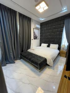 um quarto com uma cama grande com cabeceira preta em Palm & Pearl Apartment em Lekki