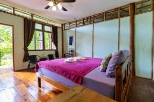 Ban Pha Saeng LangにあるBansuanphutarnのベッドルーム1室(紫色のベッドカバー付きの大型ベッド1台付)