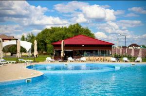 ein großer Swimmingpool mit einem Pavillon im Hintergrund in der Unterkunft Jansaya Resort база отдыха Жансая in Aleksandrovka