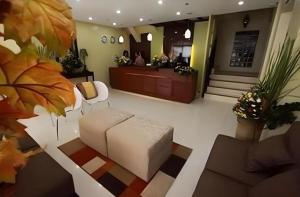 a lobby with a couch and a reception desk at Sampaguita Suites Plaza Garcia in Adlawon