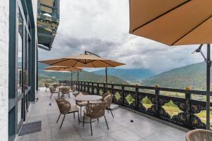 パロにあるDawa at Hilltop by Heetonのテーブルと椅子とパラソルのあるパティオ +2枚の写真