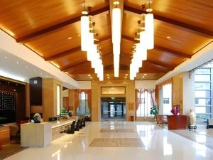 a large lobby with wood ceilings and chandeliers at Lijiang Conifer Lishui Yangguang Hotel in Lijiang