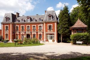 a large red brick building with a roof at Château Corneille in Vieux-Villez