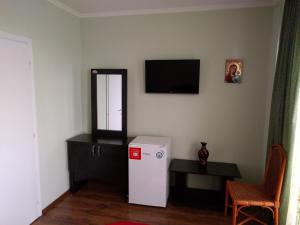 Habitación con nevera, mesa y TV. en Casa cu pauni, en Mărăcineni 63 fotos más