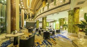 een lobby met tafels en stoelen in een gebouw bij Jincheng Pacific Hotel in Jingcheng
