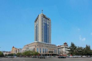 een hoog gebouw met een kruis erop bij Jincheng Pacific Hotel in Jingcheng