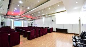 een grote kamer met rode stoelen en een podium bij Dali Dayu Hotel in Dali