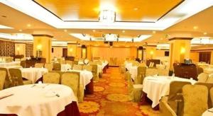 a banquet hall with white tables and chairs at Kui Chong Holiday Hotel in Tongshi