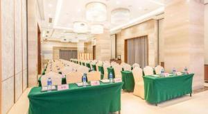 a room with green tables and chairs with bottles on them at Guangdong Workers Santorium-Sea Side Park K Building Hotel in Huidong