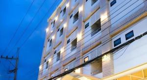 een hoog wit gebouw met lichten erop bij Loei Residence in Ban Tha Phae