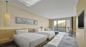 西安市にあるXian Elegant Oriental Hotelのベッド2台と薄型テレビ付きのホテルの部屋